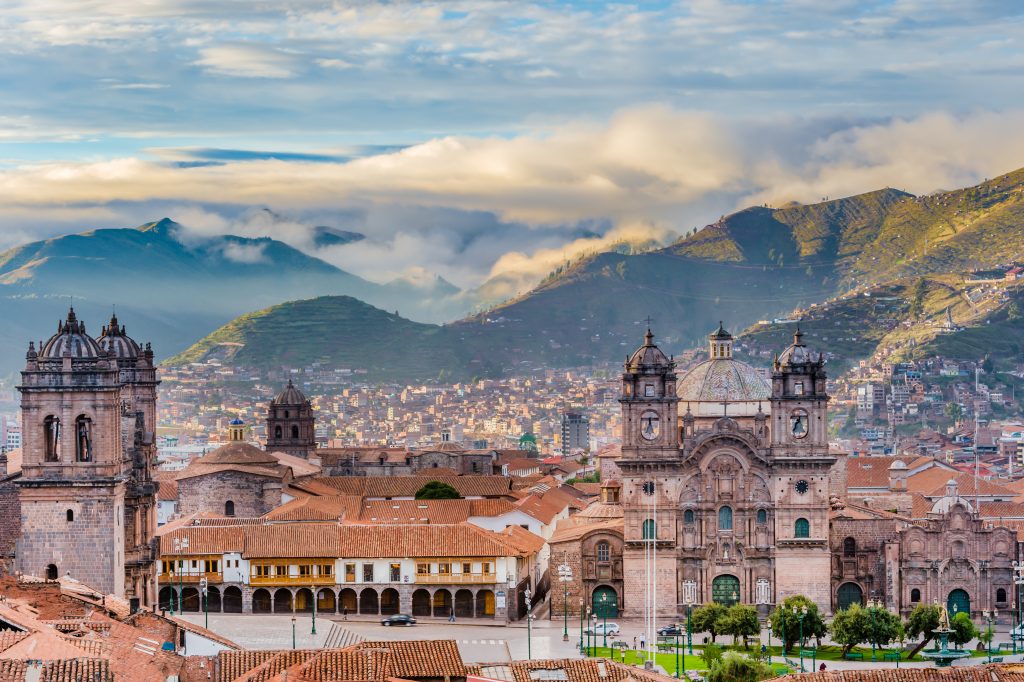 aerial view over the city of cusco with mountians in the background