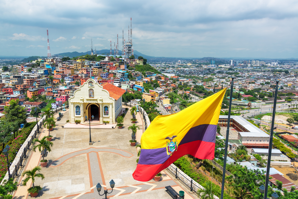 Ecuadorian flag on top of Santa Ana hill with a church and the city of Guayaquil in the background in Ecuador