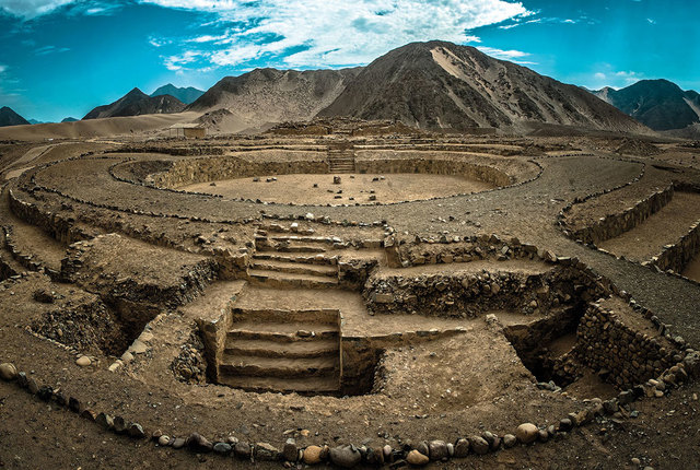 ancient ruin of Caral from above with mountain in background