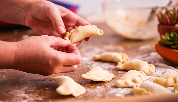 Close up of hands making homemade empanadas