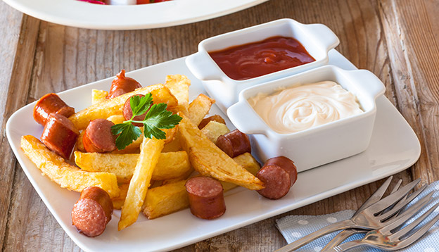 Close up of a plate of Salchipapas. Sauasages and chips