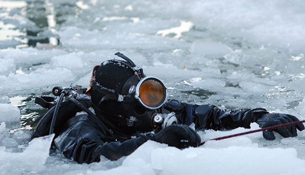 A scuba diver emerges through the icy waters of Antarctica
