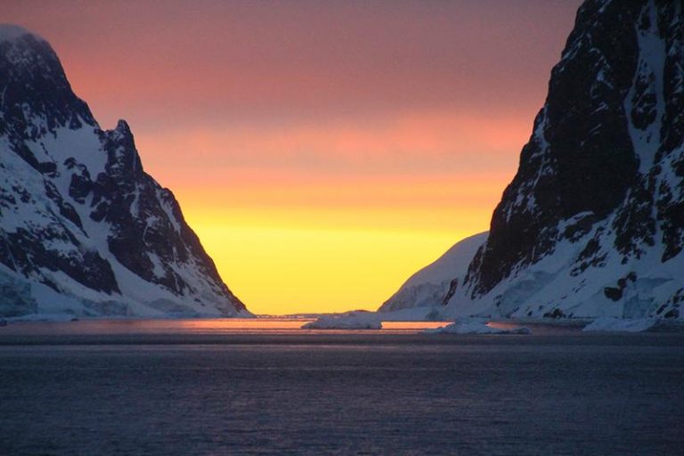 Weather in Antarctica: sunset between snowy mountains in antarctica