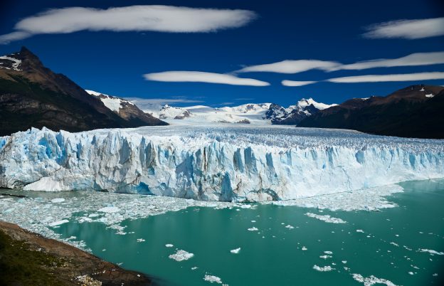 water in front of a wide, large glacier el calafate in patagonia