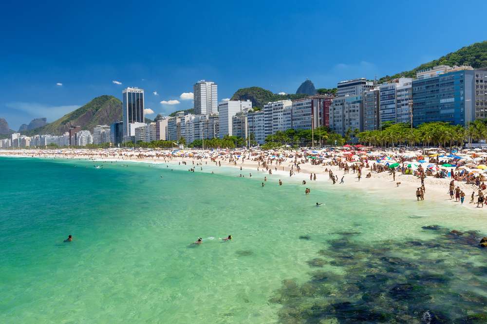 blue water and white sand beach with rio skyline