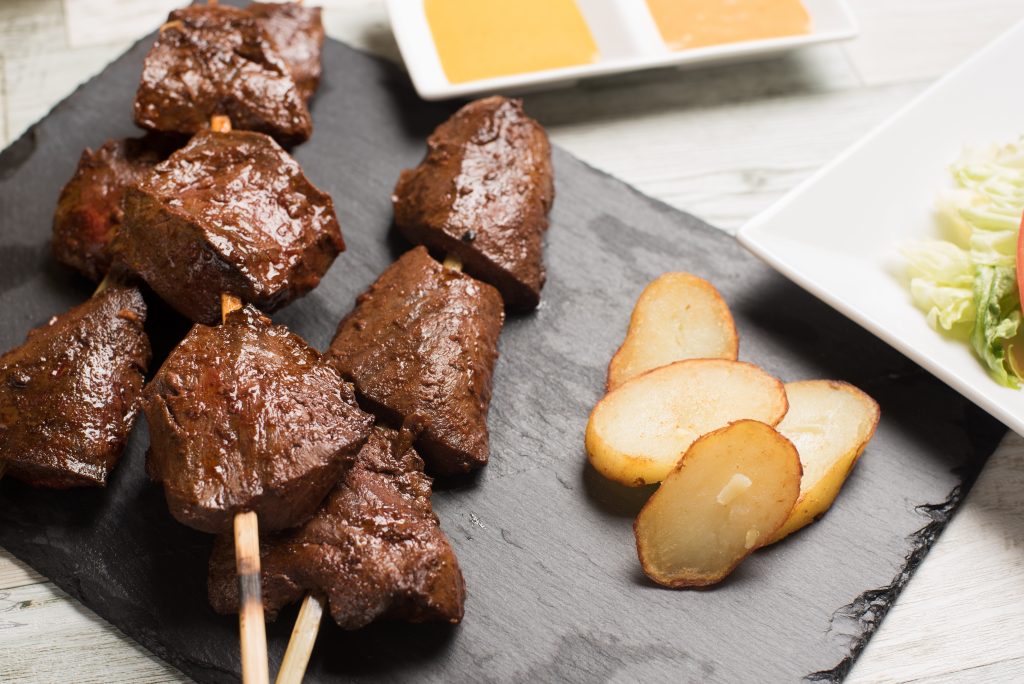 Peruvian beef heart skewers on a plate