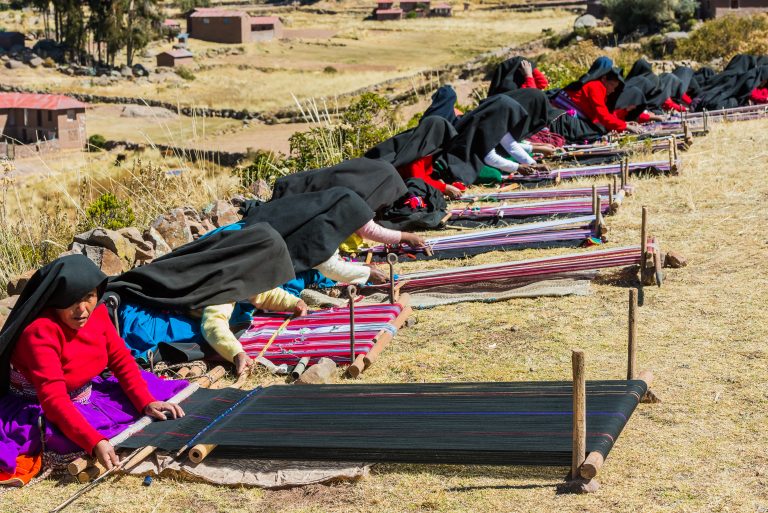 PUNO, PERU - JULY 25, 2013: women weaving in the peruvian Andes at Taquile Island credit shutterstock